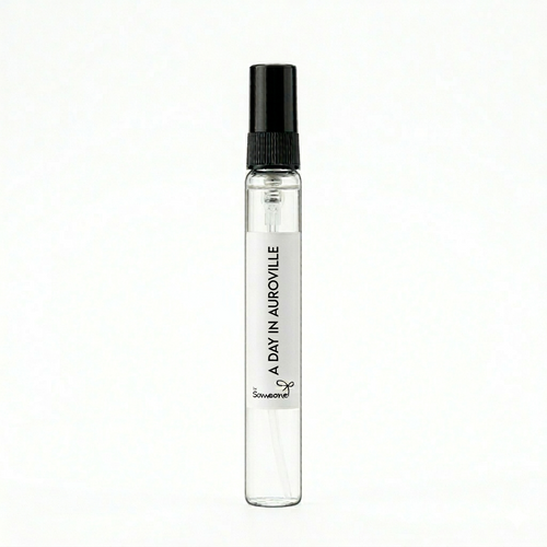 Small perfume bottle labeled 'A Day in Auroville' on a white background